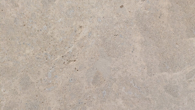 Close-up of a textured concrete surface with natural imperfections and subtle variations in tone.