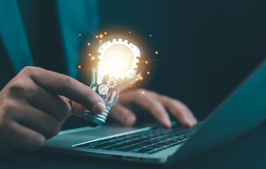 A glowing light bulb with gear icons held above a laptop symbolizes innovation, creative ideas, digital solutions, and technology development for modern business and startup projects.