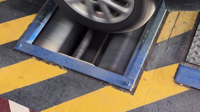 Car wheel spinning on blue chassis dynamometer test bench