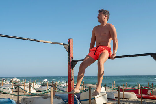 Man taking a break after calisthenics training on beach