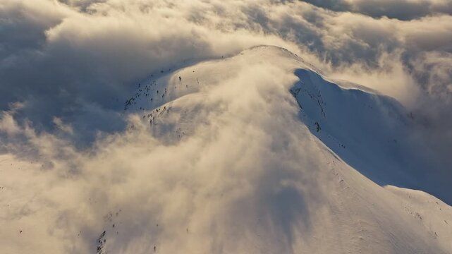 Misty cold wind unveils rocky skyline, Blizzard swirl uncovers rugged mountain crest in fog, Chilly gusts and swirling mist expose rugged mountainous silhouette with shadows