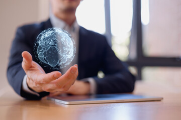 Businessman holding a digital holographic globe above a tablet, symbolizing global connection, digital transformation, innovation, worldwide business, global tech futuristic communication.