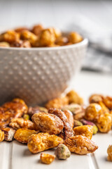 Nuts coated in sugar glaze on white table.