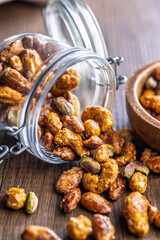 Nuts coated in sugar glaze on wooden table.