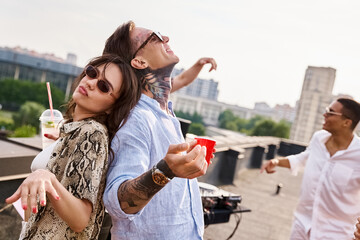 Fototapeta premium Young friends celebrate life together on a sunny rooftop with laughter and fun
