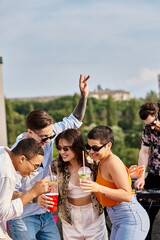 Friends enjoy a vibrant rooftop party filled with laughter and drinks under the sky