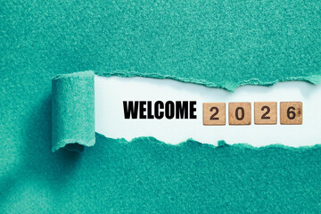 Welcome 2026 Concept Revealed Through Torn Teal Paper