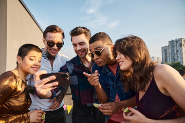 Friends enjoying a joyful rooftop gathering filled with laughter and shared moments during sunset