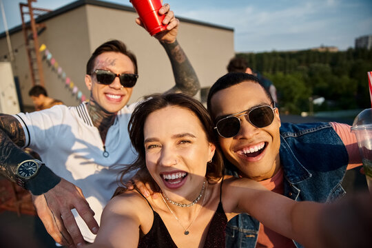 Young friends celebrate friendship and joy at a lively rooftop party as the sun sets
