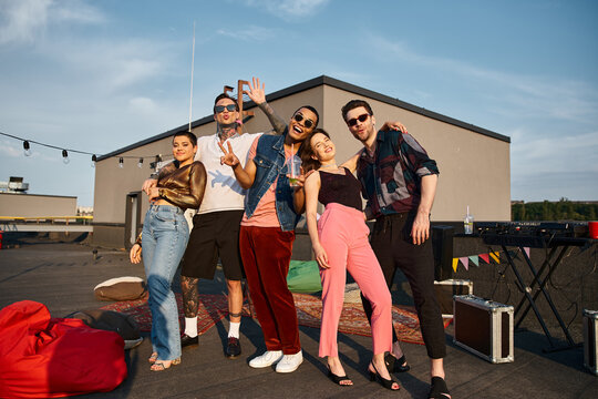 Friends enjoy a lively rooftop party under the warm sun with laughter and good vibes