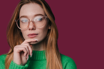 thoughtful woman in glasses considering brand strategy against minimalist background tones