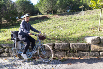 Man riding bicycle with child seat in park path