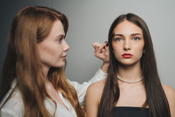 expert makeup artist applies sophisticated styling to models for fashion magazine and advertisement