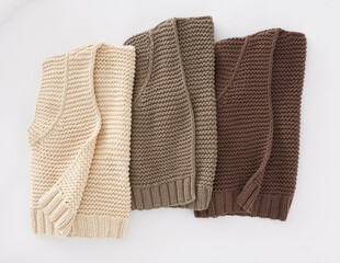 Three folded knitted cardigans in beige brown and taupe tones