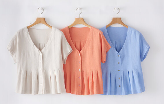 Three button down linen blouses on hangers fashion and apparel