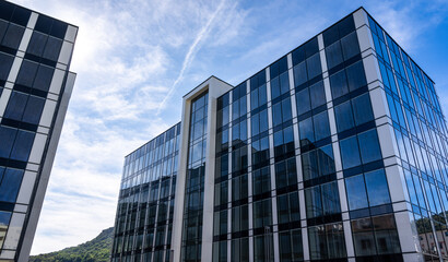 Fototapeta premium Modern Corporate Office Buildings Under a Sunny Blue Sky Reflecting Urban Business Environment