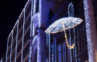 Illuminated Christmas Umbrella Decoration on Building at Night