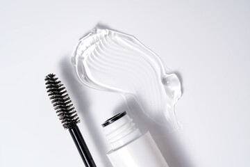 transparent eyelash eyebrow or gel serum, with black brush on white background. smooth and shiny texture stroke presentation