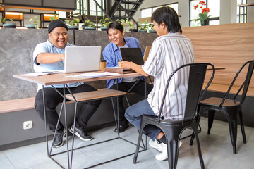 Team Collaborating On Laptops In Modern Co Working Space