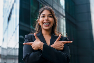 Smiling woman in business attire poses confidently outside modern office building in city