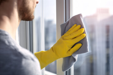 Man Cleaning Window with Yellow Gloves