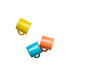 Coffee break,tea time.Blue yellow orange cups isolated on white