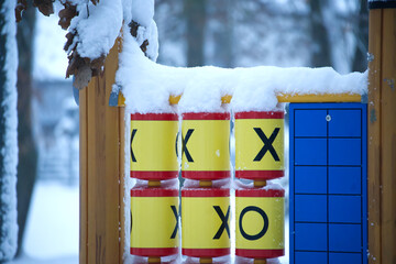 Tic-tac-toe game on a playground covered in fresh snow during winter
