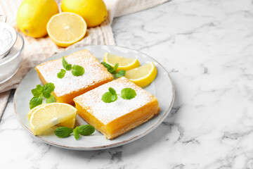Tasty lemon bars with powdered sugar, mint and fresh fruits on white marble table, closeup. Space for text
