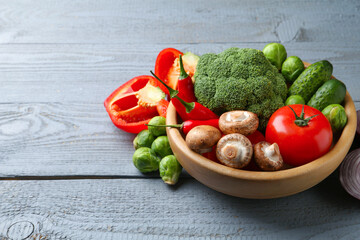Different fresh raw vegetables on grey wooden table, closeup. Space for text