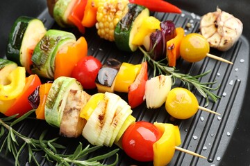 Skewers with tasty vegetables on grill pan, closeup