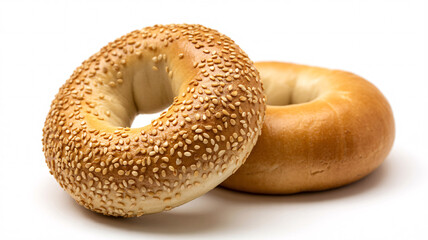Two bagels on a white surface one with sesame seeds and one plain ready to be eaten and enjoyed