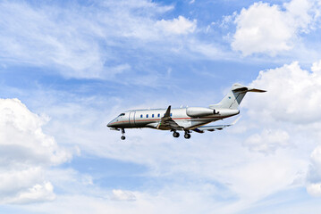 Private business plane flying under blue sky with white clouds	