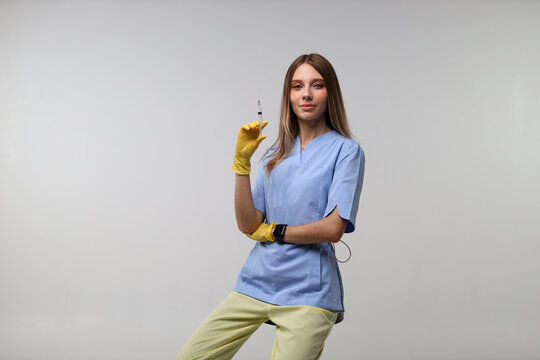 Confident young caucasian female nurse holding syringe in uniform - Powered by Adobe