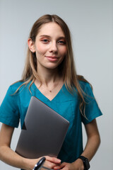 Obraz premium Caucasian female adult nurse holding tablet in teal scrubs