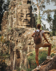 Backpacker Woman Admiring Ancient Bayon Temple Stone Face in Jungle