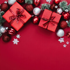 Christmas background with red surface, candies, pine brunches, gifts and glass ornaments.