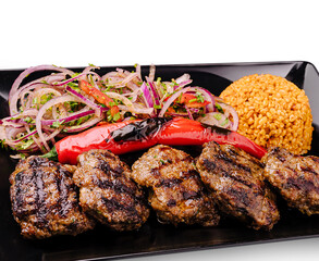 Grilled kebabs served with bulgur and fresh vegetable salad