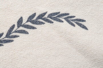 Close-up of a decorative leaf pattern on a textured fabric background