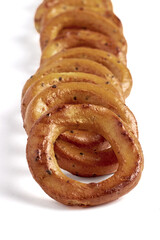 Salted pretzels with poppy seeds lined up in a row isolated on a white background.
