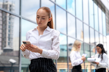 Business meeting in a modern city setting with professionals engaged in discussion and using mobile devices