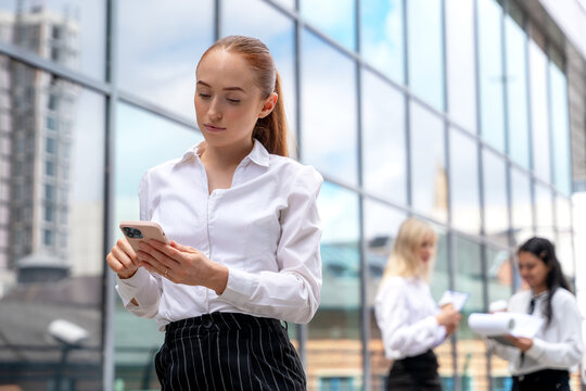 Business meeting in a modern city setting with professionals engaged in discussion and using mobile devices - Powered by Adobe