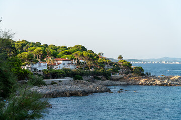 Rocky coastline and white residential villa near Platja de Sant Pol and Cala Sa Conca in S'Agar&oacute;, Costa Brava, Spain. Scenic Cam&iacute; de Ronda - famous hiking trail along the seashore.