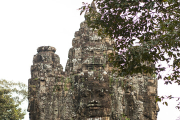 Bayon Face Towers Framed By Leaves At Angkor Thom, Cambodia Landmark