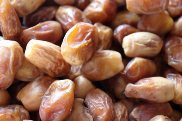 Dates extreme close up showing textured pile of fresh ripe fruit for food backgrounds