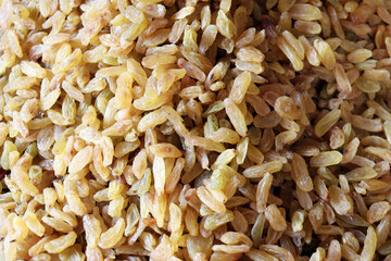 Golden raisins close up showing bright translucent dried fruit texture filling entire frame