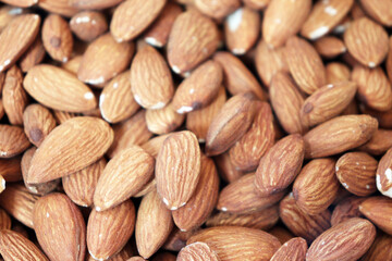 Almonds extreme close up showing dense pile of raw nuts with detailed textured surface
