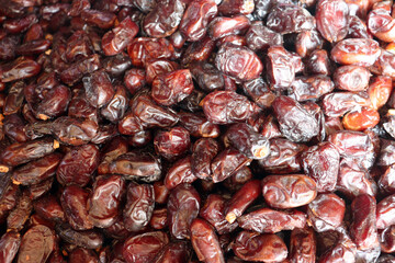 Dates extreme close up showing glossy dark burgundy fruit with rich textures