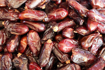 Dates extreme close up showing glossy dark burgundy fruit with rich textures