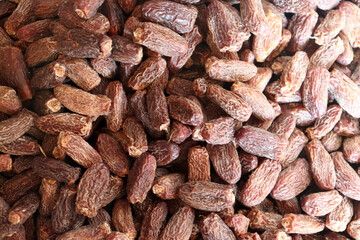 Dried dates close up showing dense pile with wrinkled skins and natural colors