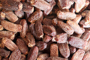 Dried dates close up showing dense pile with wrinkled skins and natural colors
